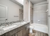 Thumbnail 69 of 128 - A bathroom with a marble countertop and a white toilet.