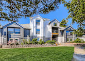 Thumbnail 28 of 34 - A large house with a grey and blue exterior and a stone wall in front.