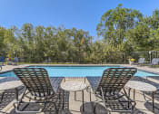 Thumbnail 21 of 51 - a swimming pool with chairs and tables next to it