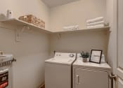 Thumbnail 14 of 51 - Fairview, OR Apartments for Rent - Laundry Room with Shelving and In-Unit Washer and Dryer.