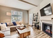 Thumbnail 2 of 51 - Fairview OR Apartments - Lodges at Lake Salish - Living Room with Hardwood-Style Flooring, Fireplace, Couch, Coffee Table, and High Ceilings