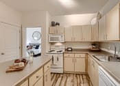 Thumbnail 6 of 51 - Fairview OR Apartments for Rent - Lodges at Lake Salish - Kitchen with Light Wood Cabinets. White Appliances, and an Island