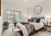 Thumbnail 8 of 51 - Fairview Apartments for Rent - Lodges at Lake Salish - Bedroom with Bed, Nightstands, Lamps, and Sliding Glass Door