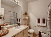 Thumbnail 11 of 51 - Apartments in Fairview, OR for Rent - Lodges at Lake Salish - Bathroom with Hardwood-Style Flooring, a Large Sink Vanity, and Modern Hardware