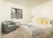 Thumbnail 9 of 13 - A bedroom with a bed, chair, and window.