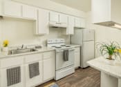 Thumbnail 11 of 13 - A kitchen with white cabinets and appliances.