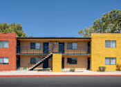 Thumbnail 9 of 17 - A yellow and red building with a staircase in the middle.
