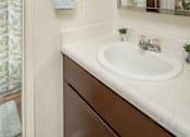 Thumbnail 11 of 20 - A bathroom with a sink, mirror, and towel.