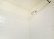 Thumbnail 17 of 20 - A white bathroom with a white tub and a shower head.