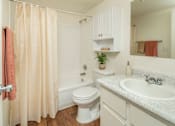 Thumbnail 18 of 22 - A bathroom with a toilet, sink, and shower.