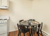 Thumbnail 14 of 22 - A white oven sits next to a table with four chairs.
