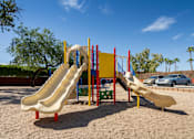 Thumbnail 20 of 22 - A playground with a yellow slide and a red and yellow structure.