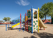 Thumbnail 21 of 22 - A playground with a slide, swings, and climbing structures.