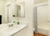 Thumbnail 11 of 13 - A white bathroom with a sink and a bathtub.