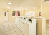 Thumbnail 10 of 13 - A laundromat with washers and dryers is shown.