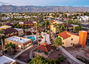 Thumbnail 1 of 13 - A sunset view of a neighborhood with a pool and a mountain in the background.