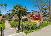 Thumbnail 3 of 13 - A sign for Park Place Apartments is in front of a building.