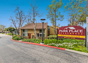 Thumbnail 6 of 13 - A sign for Park Place Apartments is in front of a building.