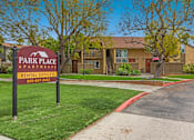 Thumbnail 1 of 13 - A sign for Park Place Apartments is in front of a building.