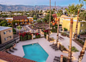 Thumbnail 8 of 13 - A pool surrounded by palm trees and a mountain range in the background.