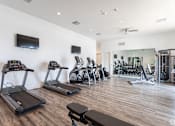 Thumbnail 36 of 45 - A gym with treadmills, exercise bikes, and other equipment.