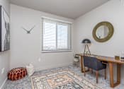 Thumbnail 7 of 45 - A room with a desk, chair, and a rug.