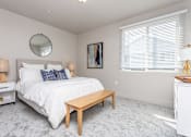 Thumbnail 5 of 45 - A bedroom with a large bed, a round mirror, and a painting on the wall.