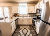 Thumbnail 20 of 45 - A kitchen with a black and white patterned rug on the floor.