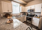 Thumbnail 21 of 45 - A kitchen with granite countertops and stainless steel appliances.