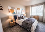 Thumbnail 22 of 45 - A bedroom with a bed, nightstand, and a deer head on the wall.