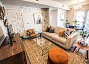 Thumbnail 9 of 45 - A living room with a couch, a coffee table, and a television.