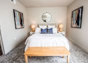 Thumbnail 27 of 45 - A bedroom with a white bed and a wooden coffee table.