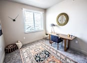 Thumbnail 29 of 45 - A room with a rug on the floor and a clock on the wall.