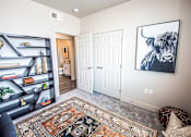 Thumbnail 31 of 45 - A room with a rug on the floor and a painting of a bull on the wall.