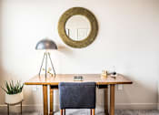 Thumbnail 32 of 45 - A table with a chair and a mirror on the wall.