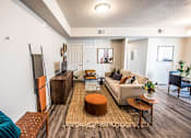 Thumbnail 10 of 45 - A living room with a brown rug and a white couch.