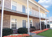 Thumbnail 4 of 10 - A house with a blue door and a white railing.