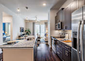 Thumbnail 2 of 35 - Gourmet kitchen with stainless steel appliances, subway tile backsplash, center island, and pendant lighting.