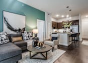 Thumbnail 5 of 35 - Contemporary apartment living room with stylish seating, modern lighting, and seamless flow into the kitchen and dining area.