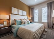 Thumbnail 11 of 35 - Spacious bedroom with plush carpeting, large windows, ceiling fan, and modern décor.