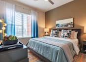 Thumbnail 12 of 35 - Spacious bedroom with plush carpeting, large windows, ceiling fan, and modern décor.