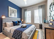 Thumbnail 13 of 35 - Spacious bedroom with plush carpeting, large windows, ceiling fan, and modern décor.