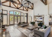 Thumbnail 23 of 26 - A large, open-concept living room with a high ceiling and wooden beams.