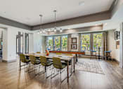 Thumbnail 21 of 26 - A modern dining room with a long table and chairs.