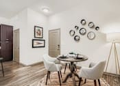 Thumbnail 9 of 26 - A dining room with a round table and chairs.