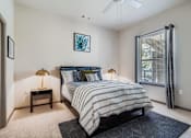 Thumbnail 8 of 26 - A bedroom with a bed, nightstands, and a ceiling fan.