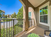 Thumbnail 11 of 26 - A balcony with a metal railing and a window overlooking a body of water.