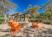 Thumbnail 18 of 26 - A patio with orange chairs and a gazebo.