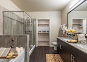 Thumbnail 14 of 35 - Modern bathroom with granite countertop, framed mirror, and dark wood vanity cabinetry.