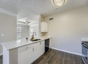 Thumbnail 14 of 32 - A kitchen with white cabinets and a white counter top.